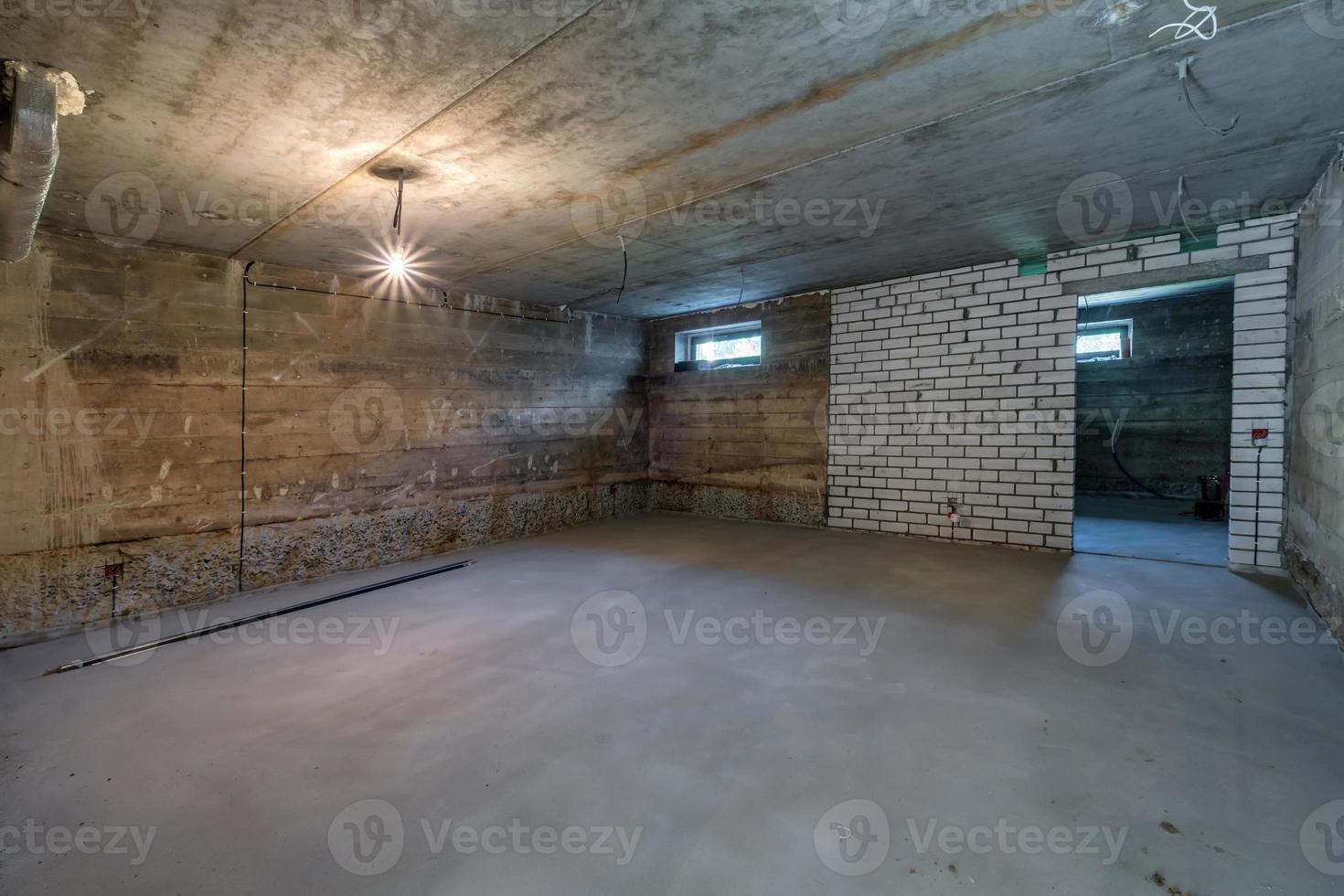Empty unfurnished basement room with minimal preparatory repairs. interior with white brick walls photo