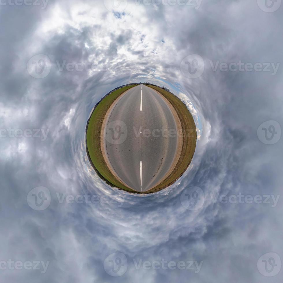 tiny planet in blue sky with beautiful clouds. Transformation of spherical panorama 360 degrees. Spherical abstract aerial view. Curvature of space. photo