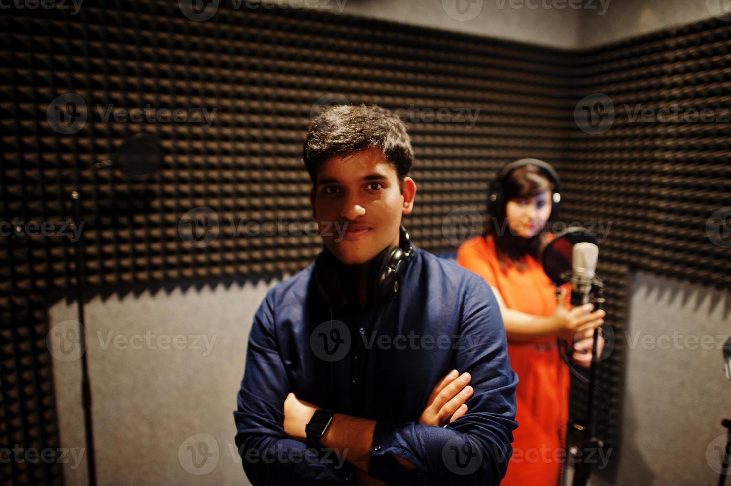 jóvenes cantantes de dúo asiáticos con micrófono grabando una canción en un estudio de grabación de música. foto