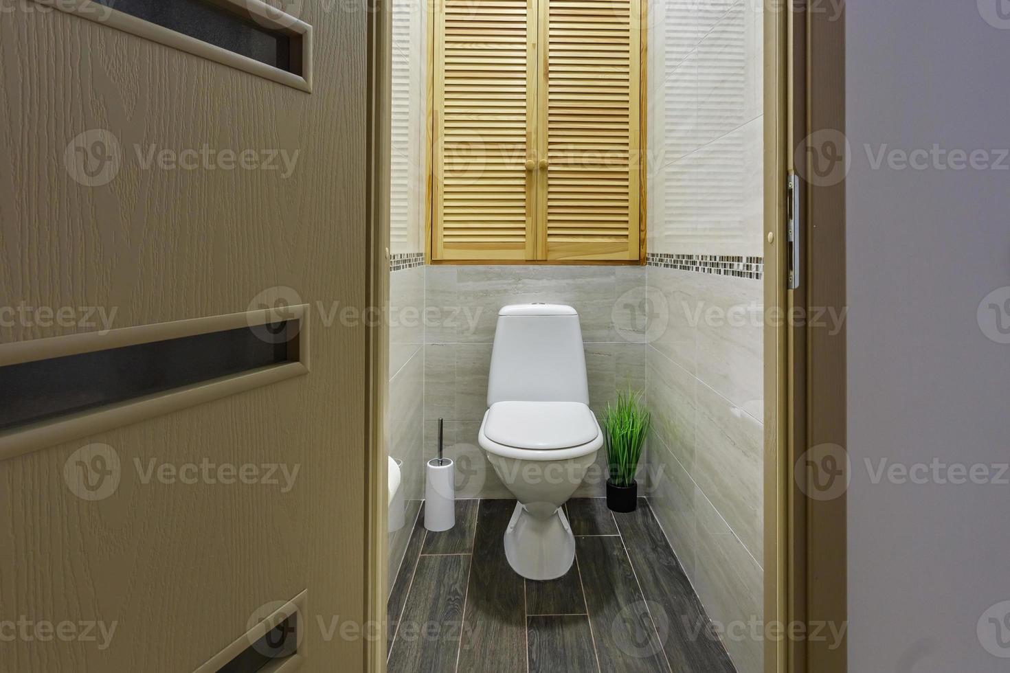 white ceramic toilet bowl in restroom photo