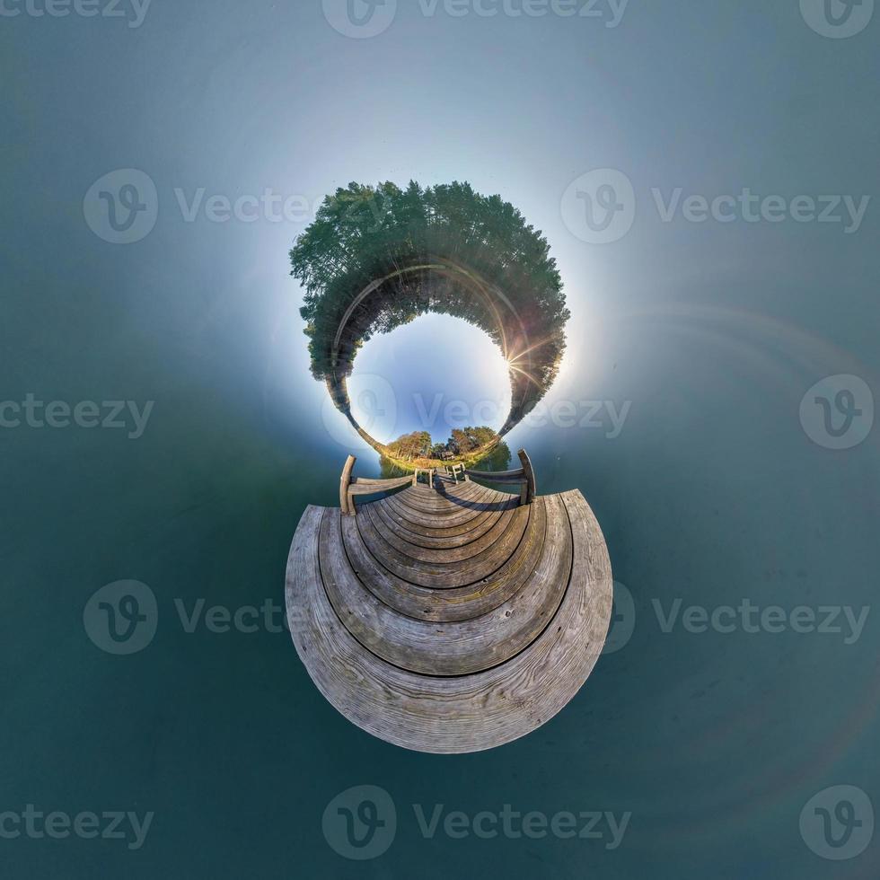 Abstract inversion of little planet transformation of spherical panorama 360 degrees. Spherical abstract aerial view on wooden pier near lake. Curvature of space. photo