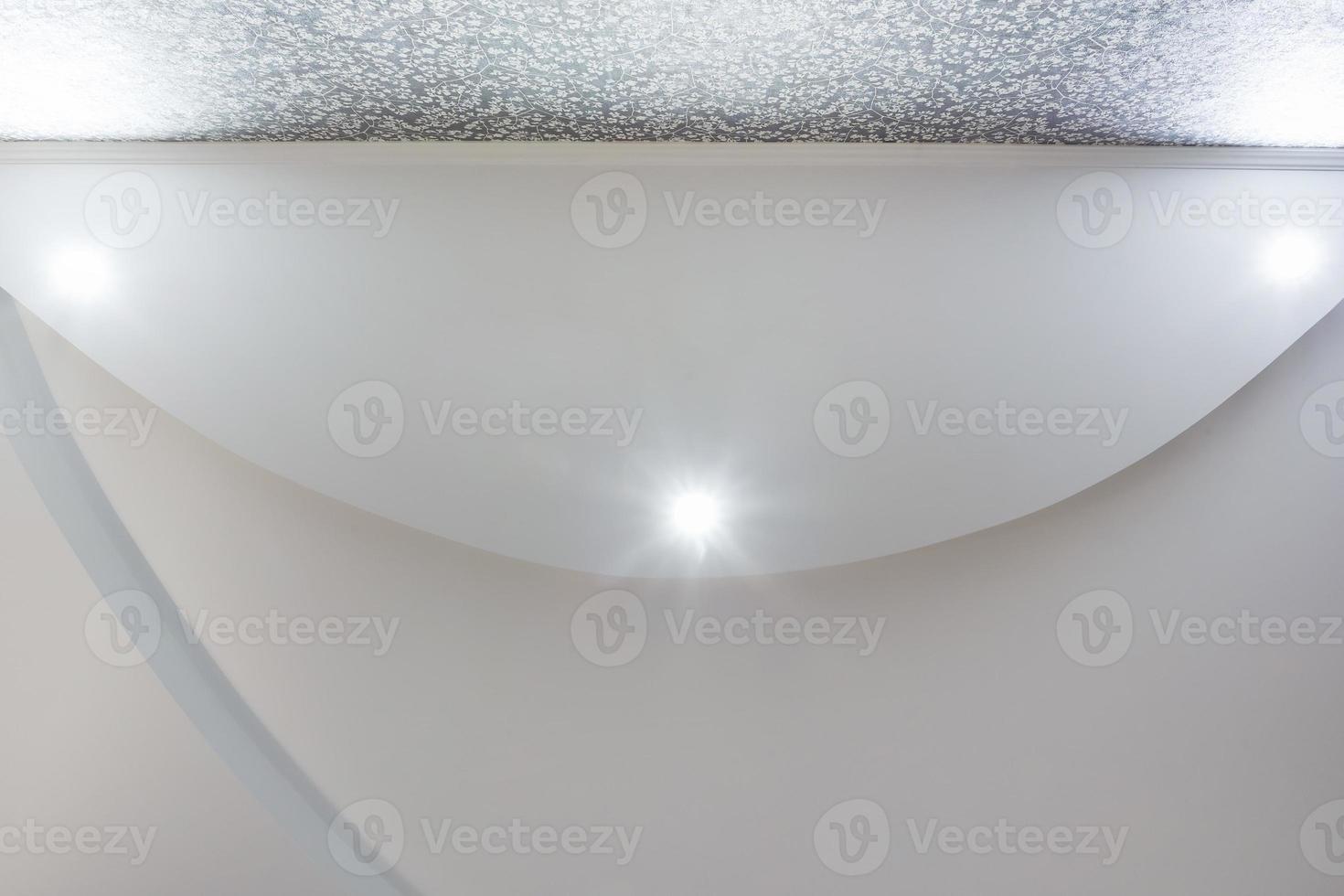 Detail of corner ceiling with intricate crown molding. Suspended ceiling and drywall construction in empty room in apartment or house. Stretch ceiling white and complex shape. photo