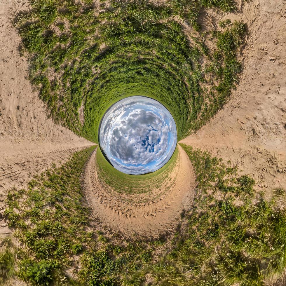 blue sky ball in middle of swirling road with grass. Inversion of tiny planet transformation of spherical panorama 360 degrees. Curvature of space. photo