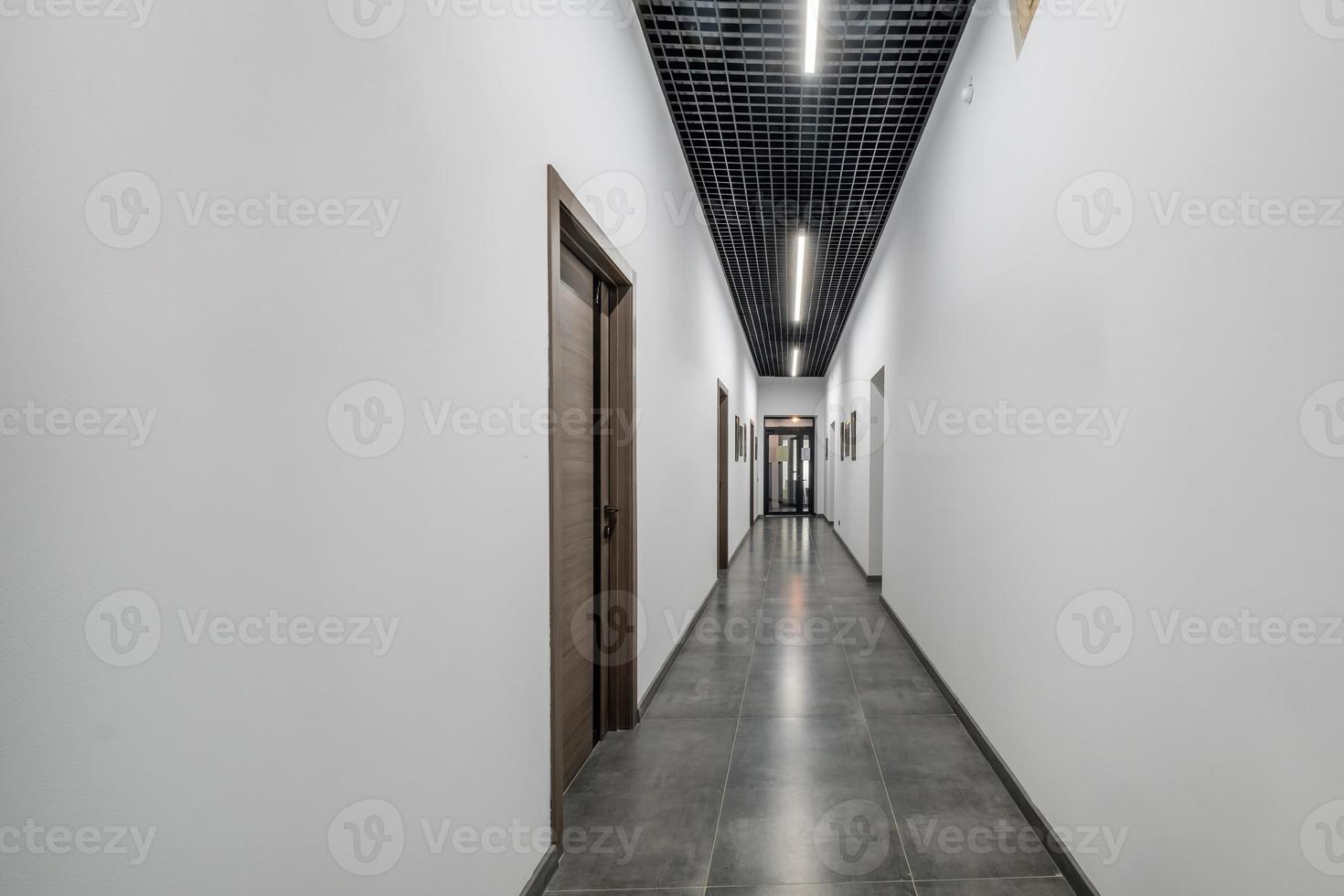 long white empty corridor in interior of entrance hall of modern apartments, office or clinic photo