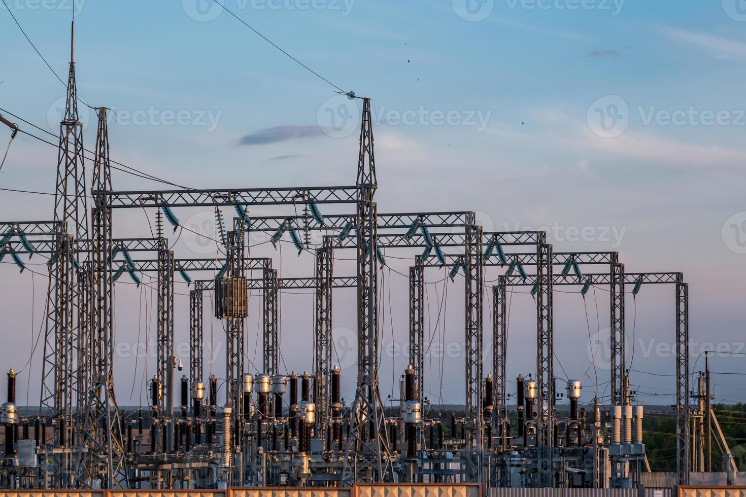 Silhouette of the high voltage electric pylon towers on the background of beautiful evening clouds photo