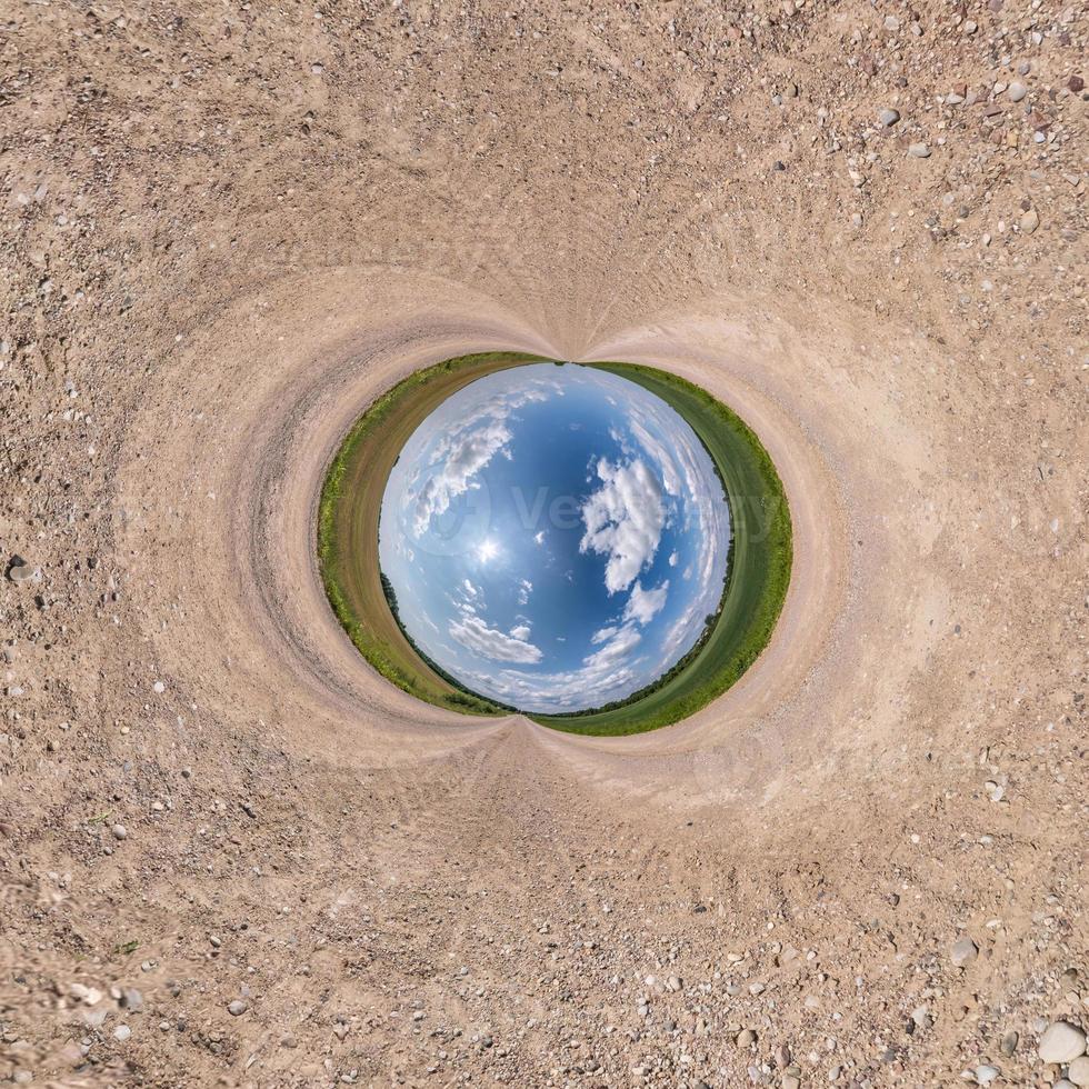 Inversion of blue little planet transformation of spherical panorama 360 degrees. Spherical abstract aerial view on road with awesome beautiful clouds. Curvature of space. photo