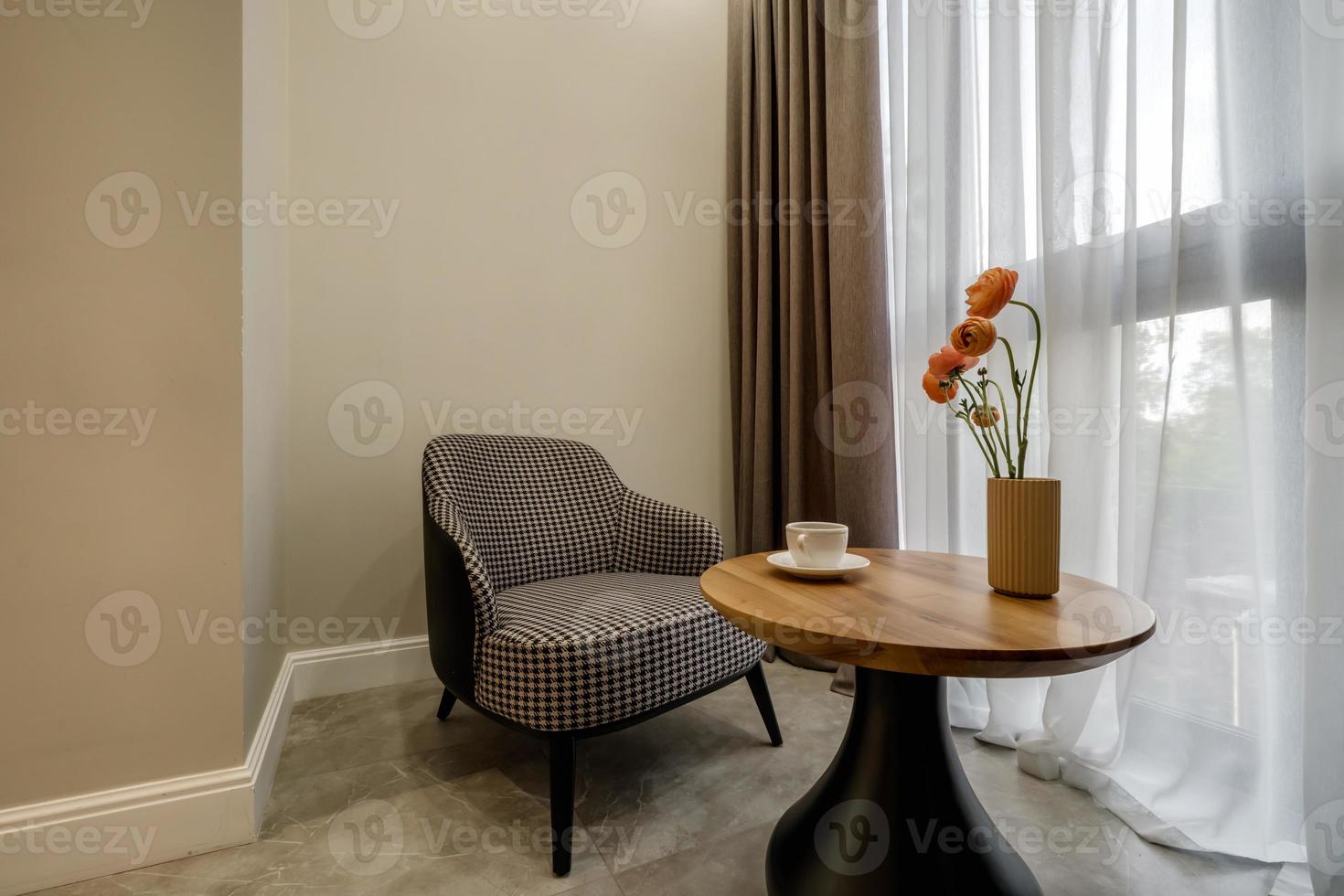 decor elements of the guest room and rest room with a tea table, an armchair and a bouquet of flowers and a cup of coffee photo