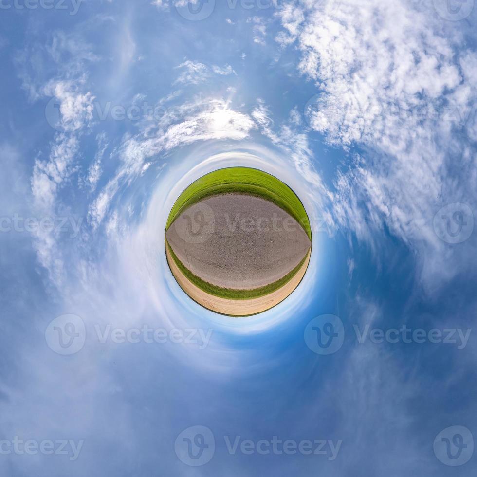 tiny planet transformation of spherical panorama 360 degrees. Spherical abstract aerial view in field with clear sky and awesome beautiful clouds. Curvature of space. photo