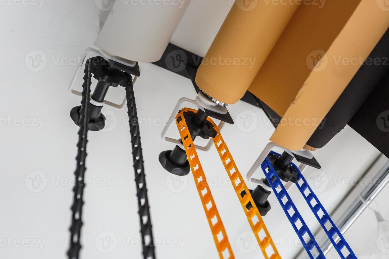 mounting manual support system for photo backdrops in modern studio. Rolls of colorful paper backgrounds for photo studio hang on the wall