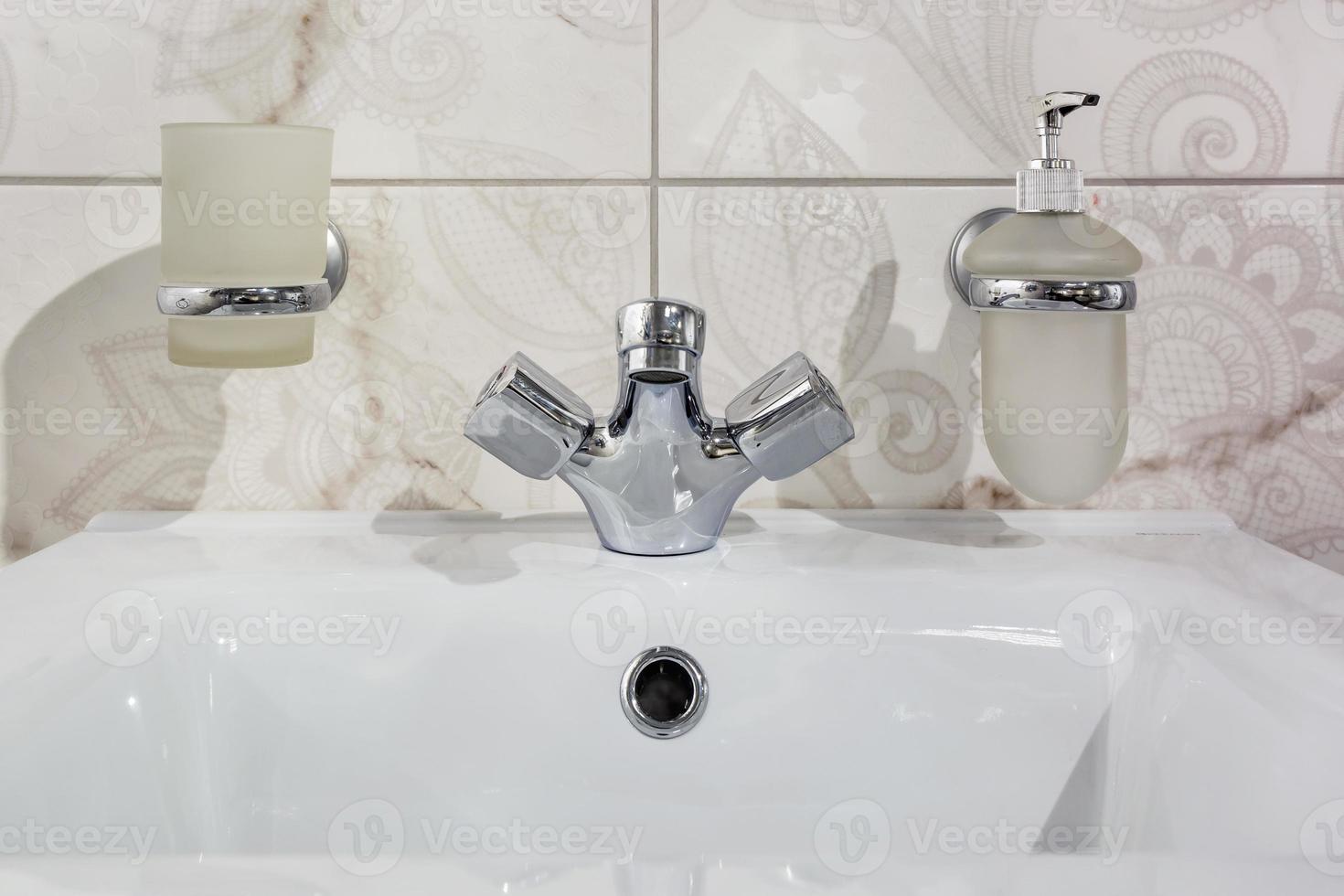 Ceramic Water tap sink with faucet with soap and shampoo dispensers in expensive loft bathroom or kitchen photo