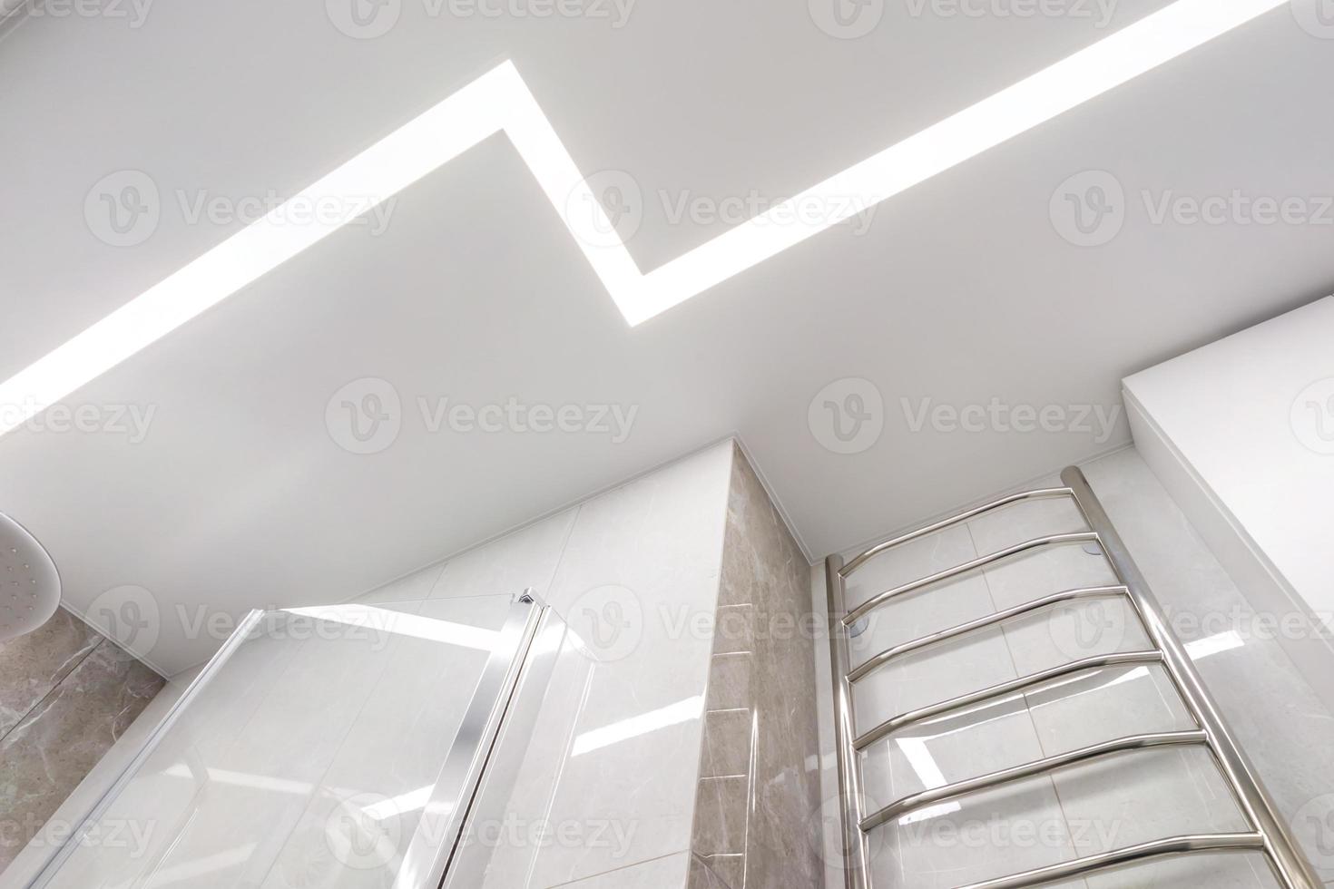 suspended ceiling with halogen spots lamps and drywall construction in empty room in apartment or house. Stretch ceiling white and complex shape. photo