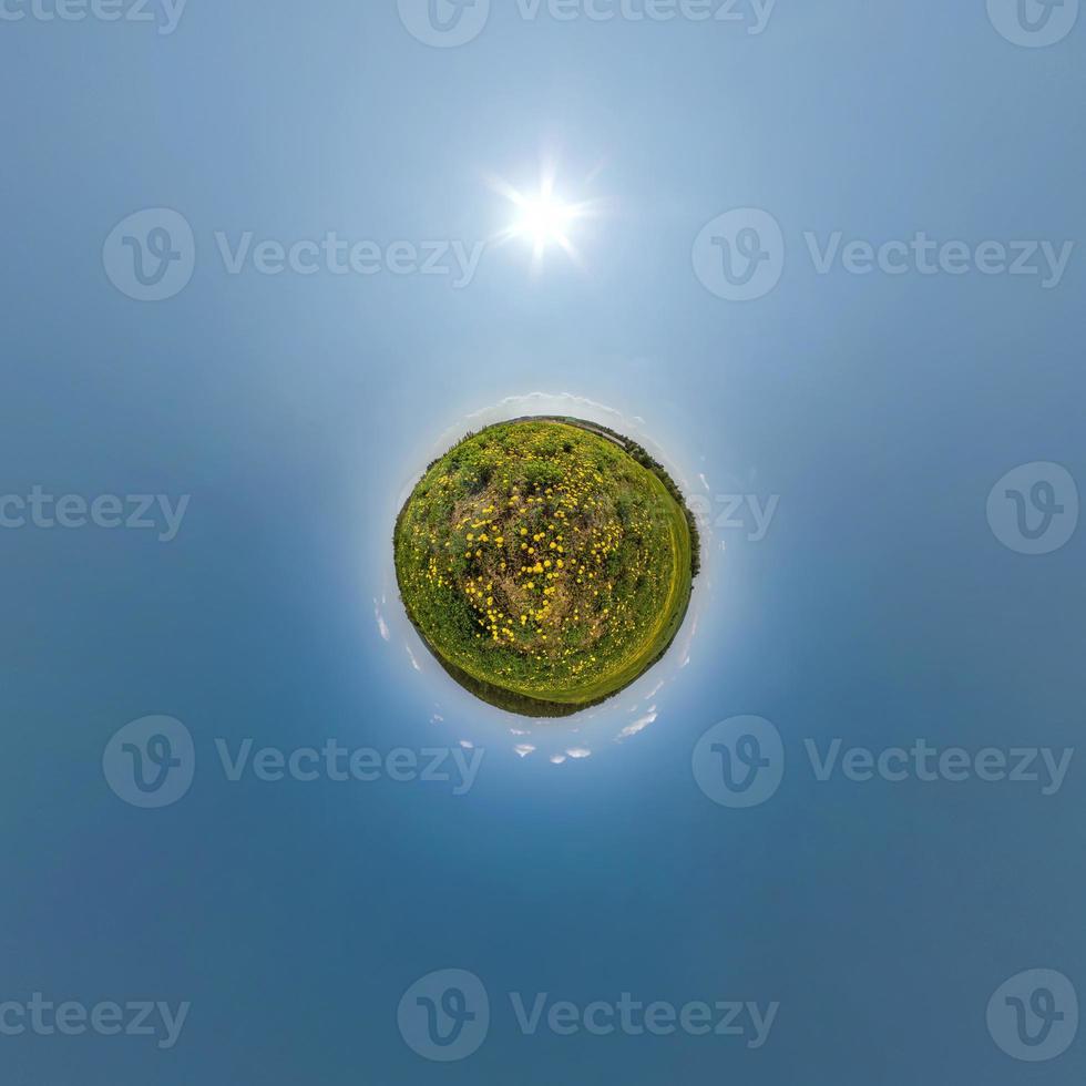 tiny planet on dandelion field in blue sky with beautiful clouds. Transformation of spherical panorama 360 degrees. Spherical abstract aerial view. Curvature of space. photo