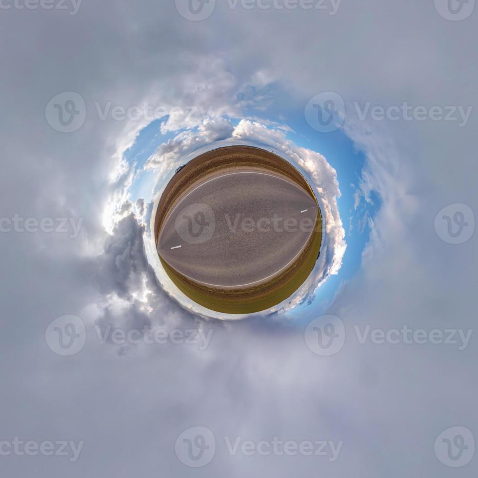 tiny planet in blue sky with beautiful clouds. Transformation of spherical panorama 360 degrees. Spherical abstract aerial view. Curvature of space. photo