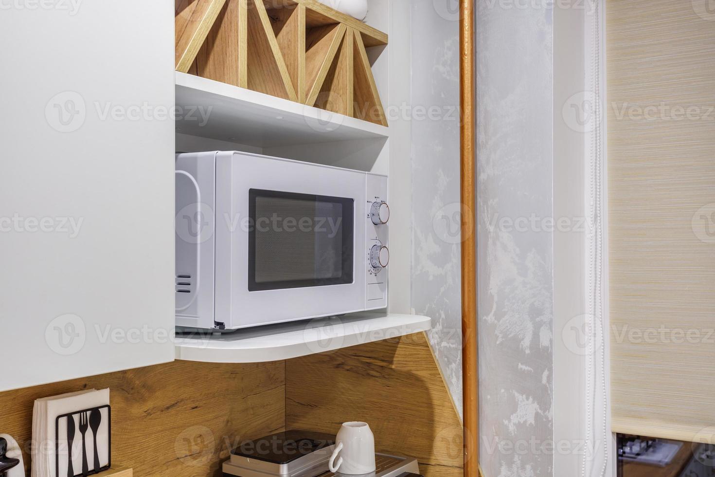 Interior of the small living equipped kitchen in studio apartments in minimalistic style with light color photo