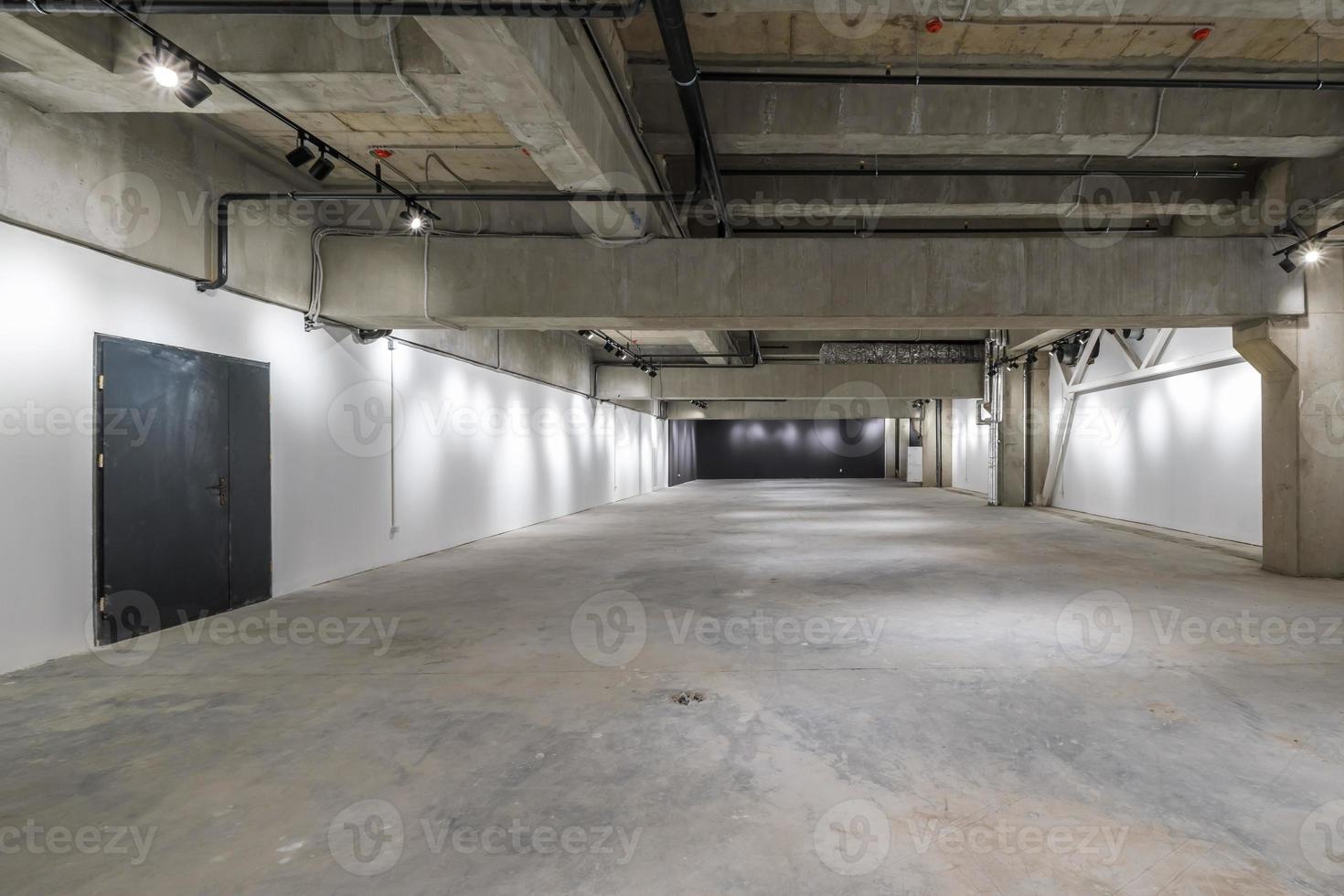 interior vacío de una gran sala de hormigón como almacén o hangar con focos foto