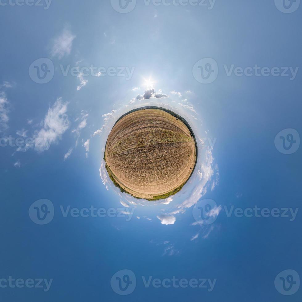 tiny planet in blue sky with sun and beautiful clouds. Transformation of spherical panorama 360 degrees. Spherical abstract aerial view. Curvature of space. photo
