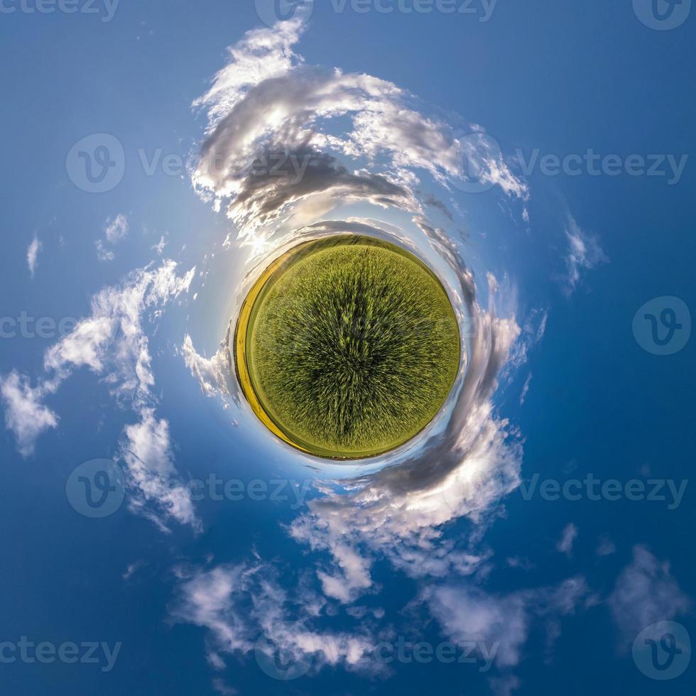 tiny planet in blue sky with sun and beautiful clouds. Transformation of spherical panorama 360 degrees. Spherical abstract aerial view. Curvature of space. photo