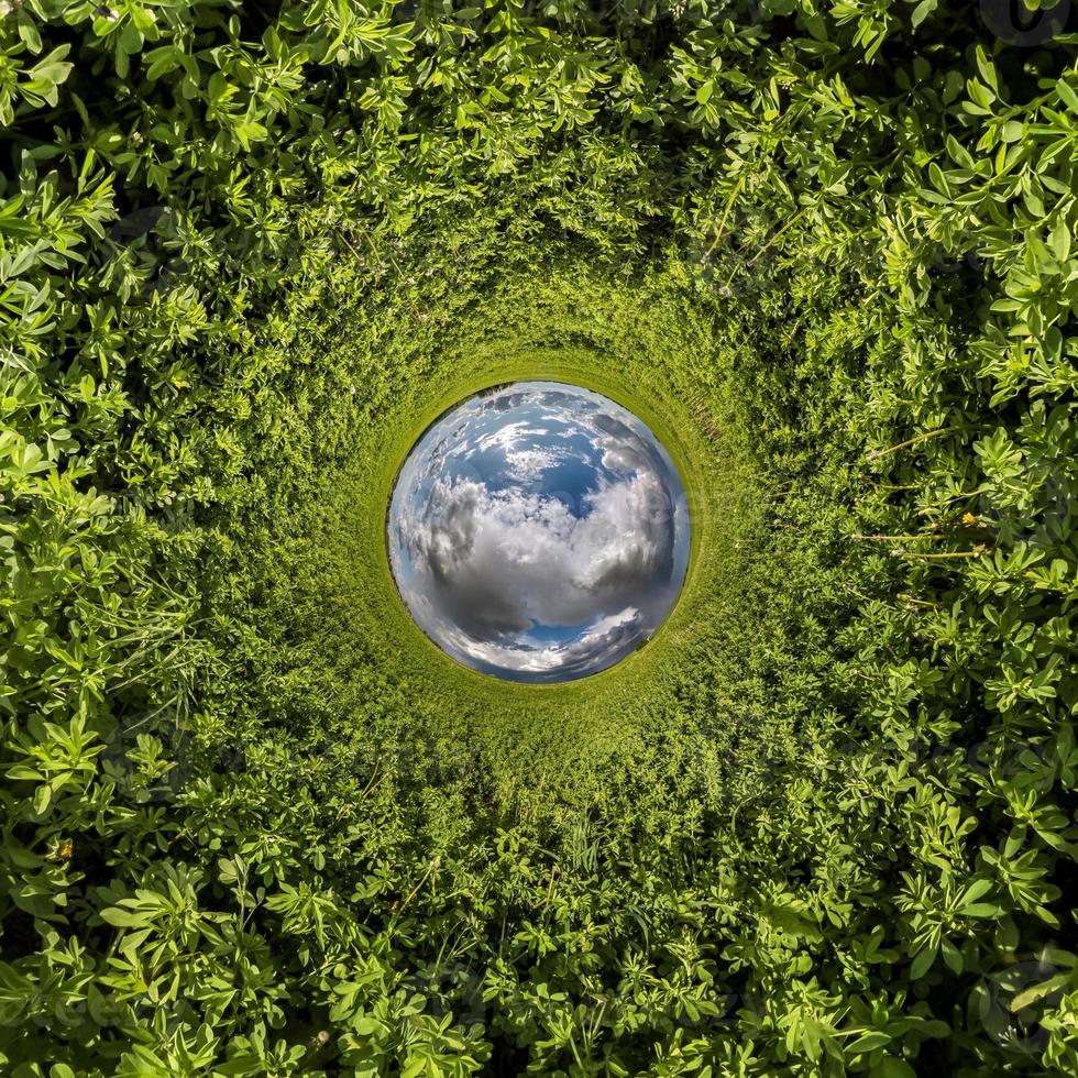 inversión de la transformación del pequeño planeta azul del panorama esférico de 360 grados. vista aérea abstracta esférica en el campo de hierba verde con impresionantes nubes hermosas. curvatura del espacio. foto