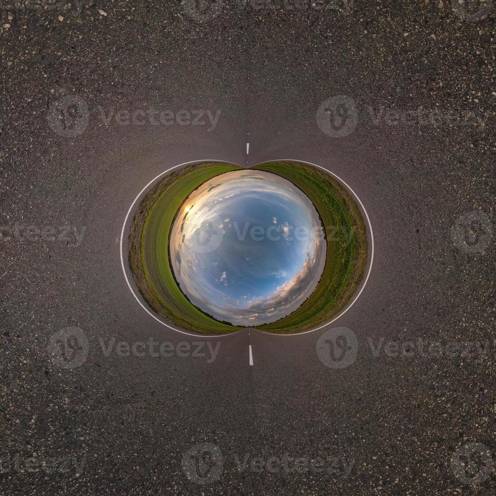 Inversion of blue little planet transformation of spherical panorama 360 degrees. Spherical abstract aerial view on road with awesome beautiful clouds. Curvature of space. photo