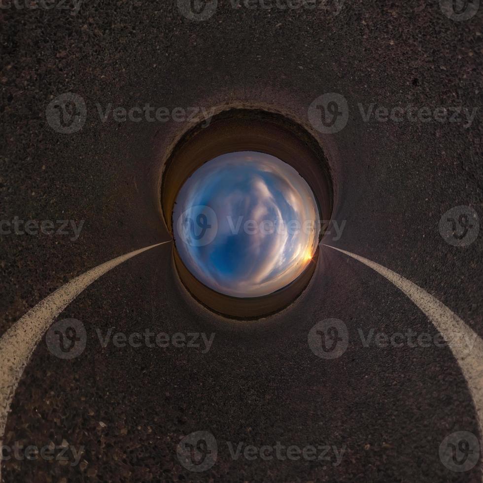 Inversion of blue little planet transformation of spherical panorama 360 degrees. Spherical abstract aerial view on road with awesome beautiful clouds. Curvature of space. photo