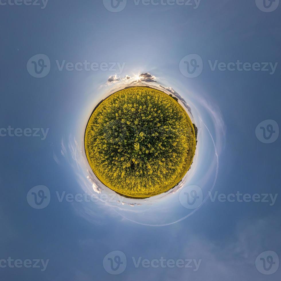 yellow tiny planet in rapeseed field in blue sky with beautiful clouds. Transformation of spherical panorama 360 degrees. Spherical abstract aerial view. Curvature of space. photo