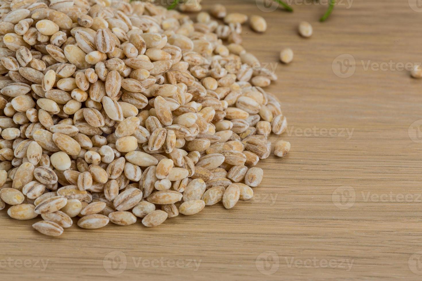Raw pearl barley on wooden background photo