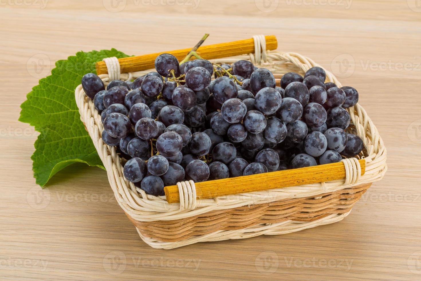 Grape in a basket on wooden background photo