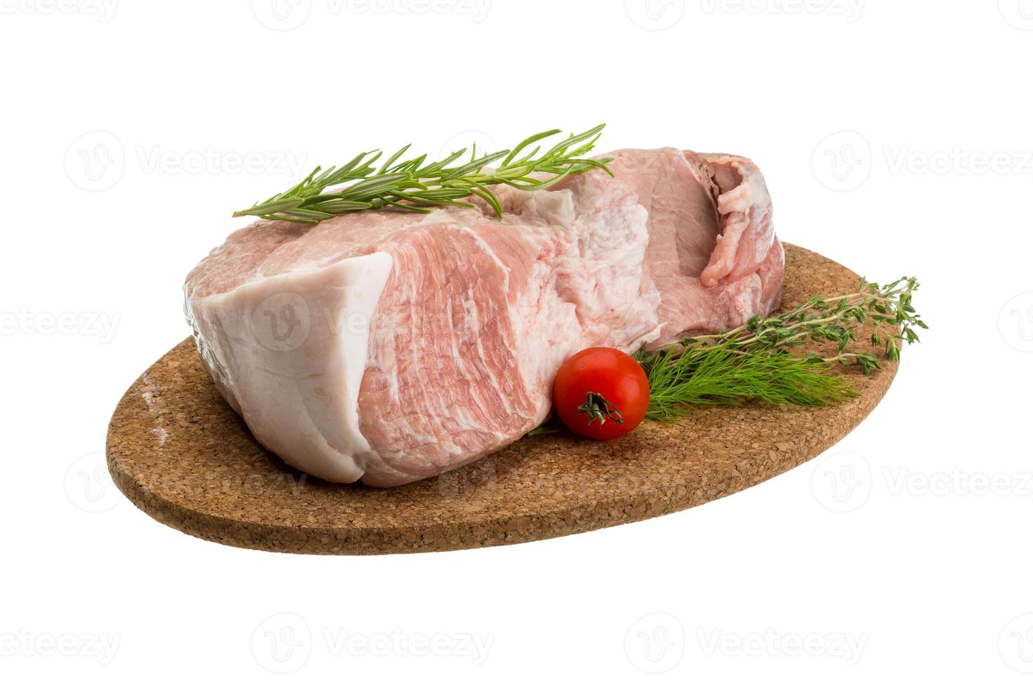 carne de cerdo cruda en placa de madera y fondo blanco foto