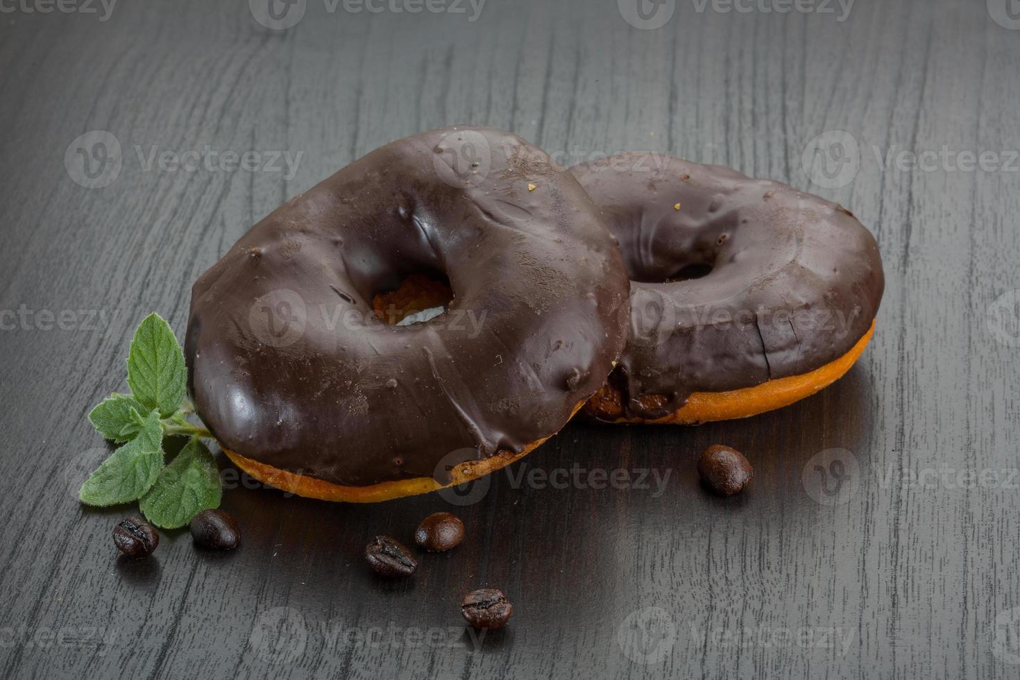 Chocolate donuts on wooden background photo