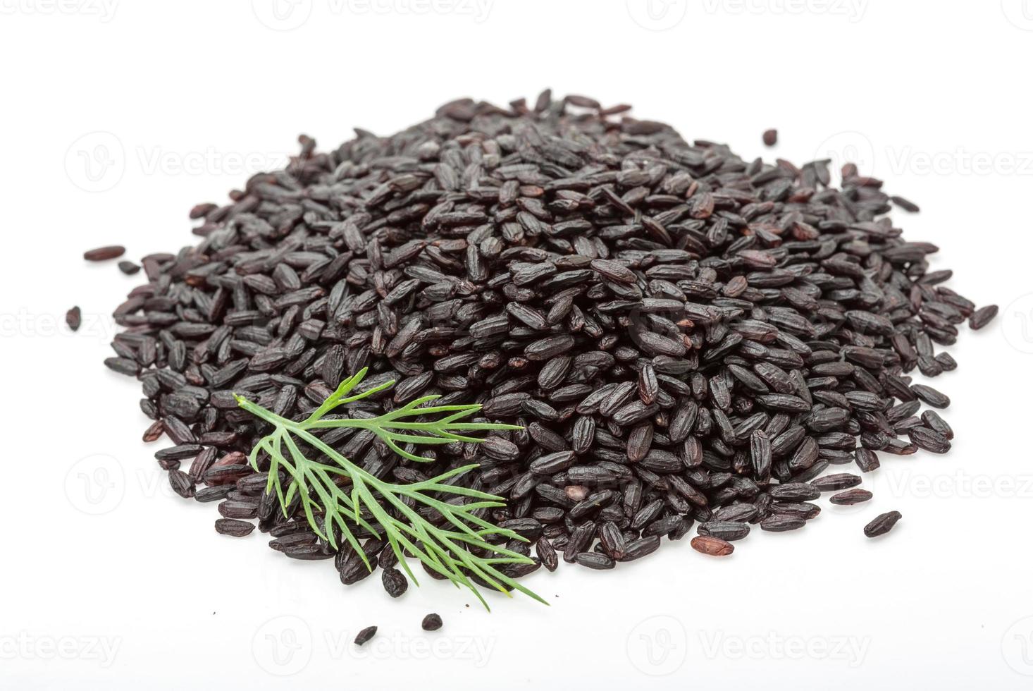 Black rice heap on white background photo
