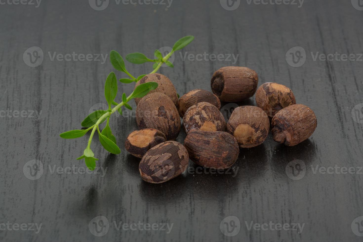 Small nutmeg on wooden background photo