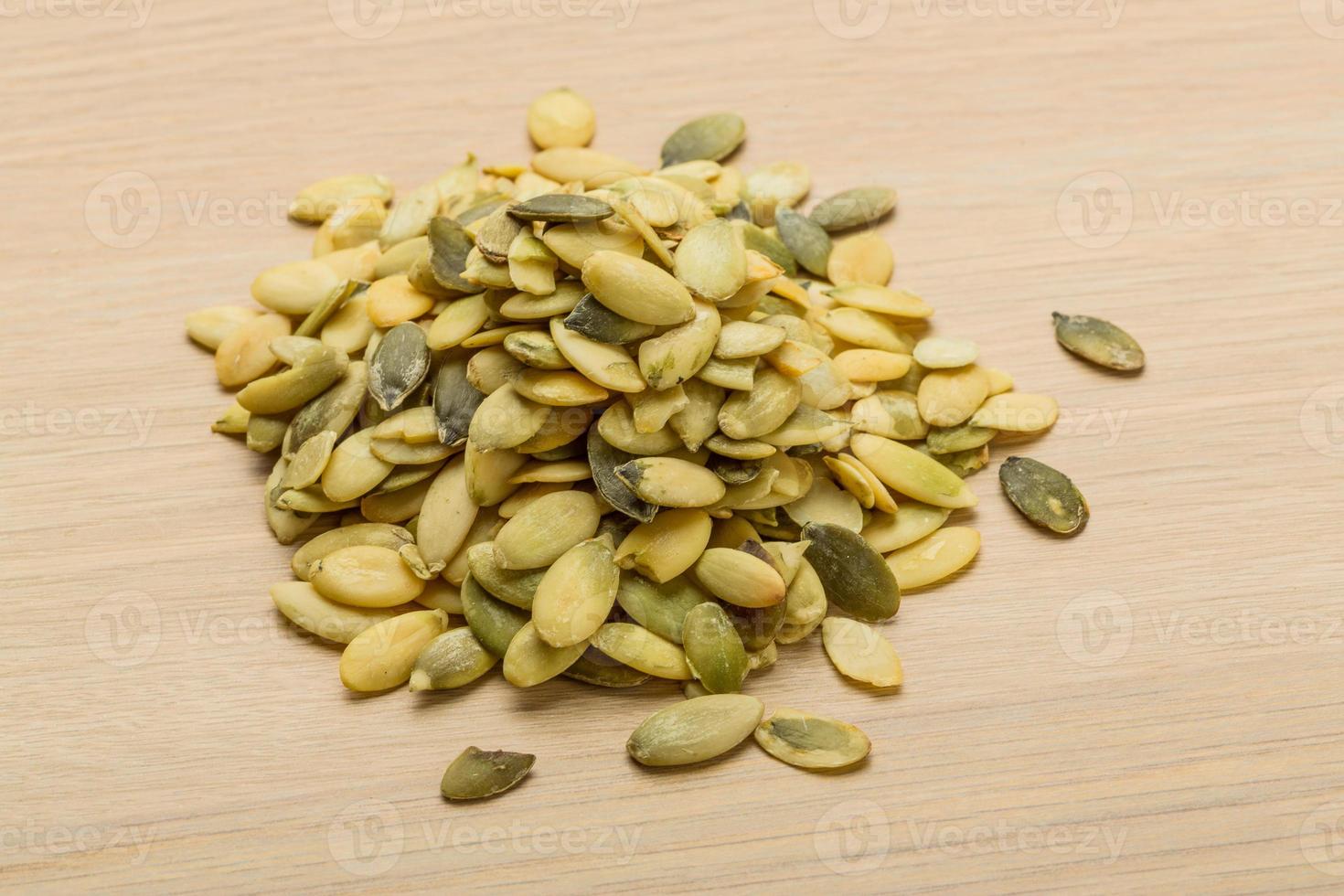 Pumpkin seeds on wooden background photo