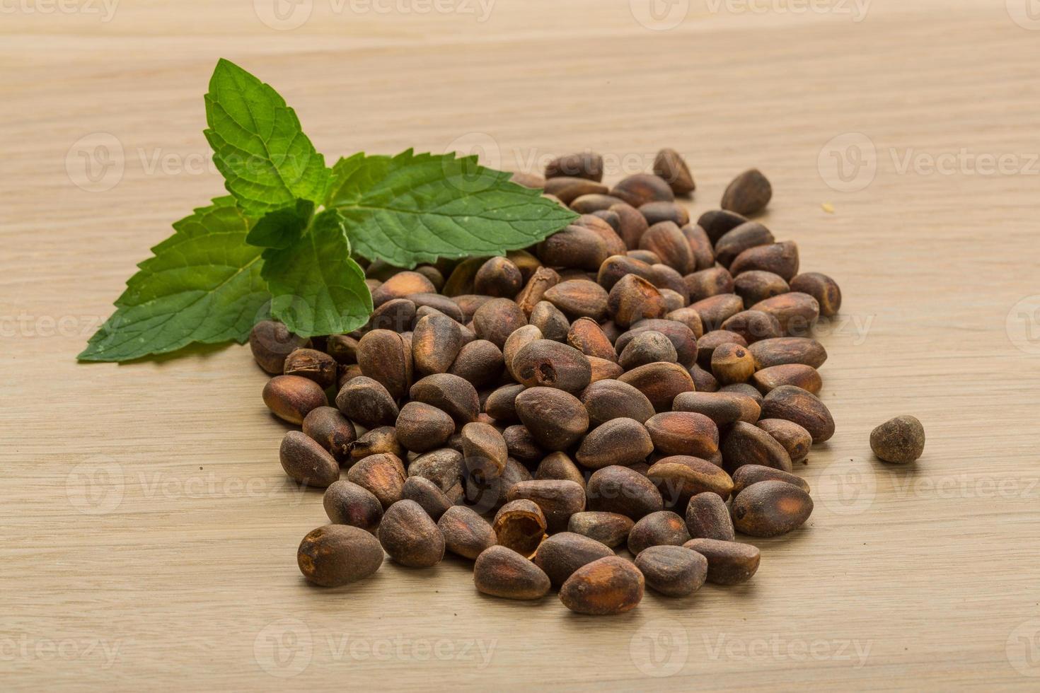 Cedar nuts on wooden background photo