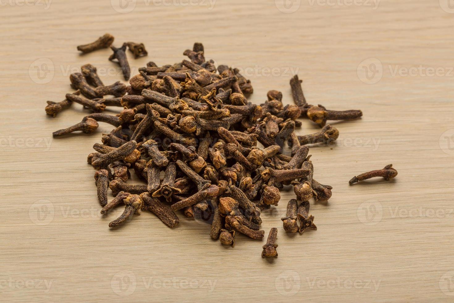 Clove seeds on wooden background photo