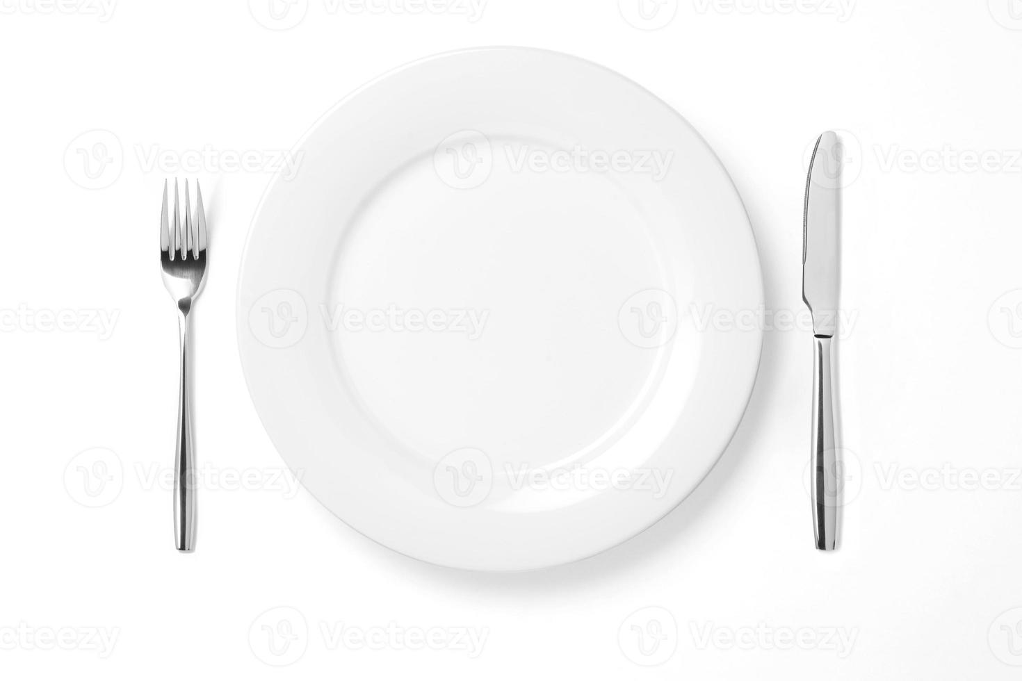 Empty plate with knife and fork isolated on a white background. photo