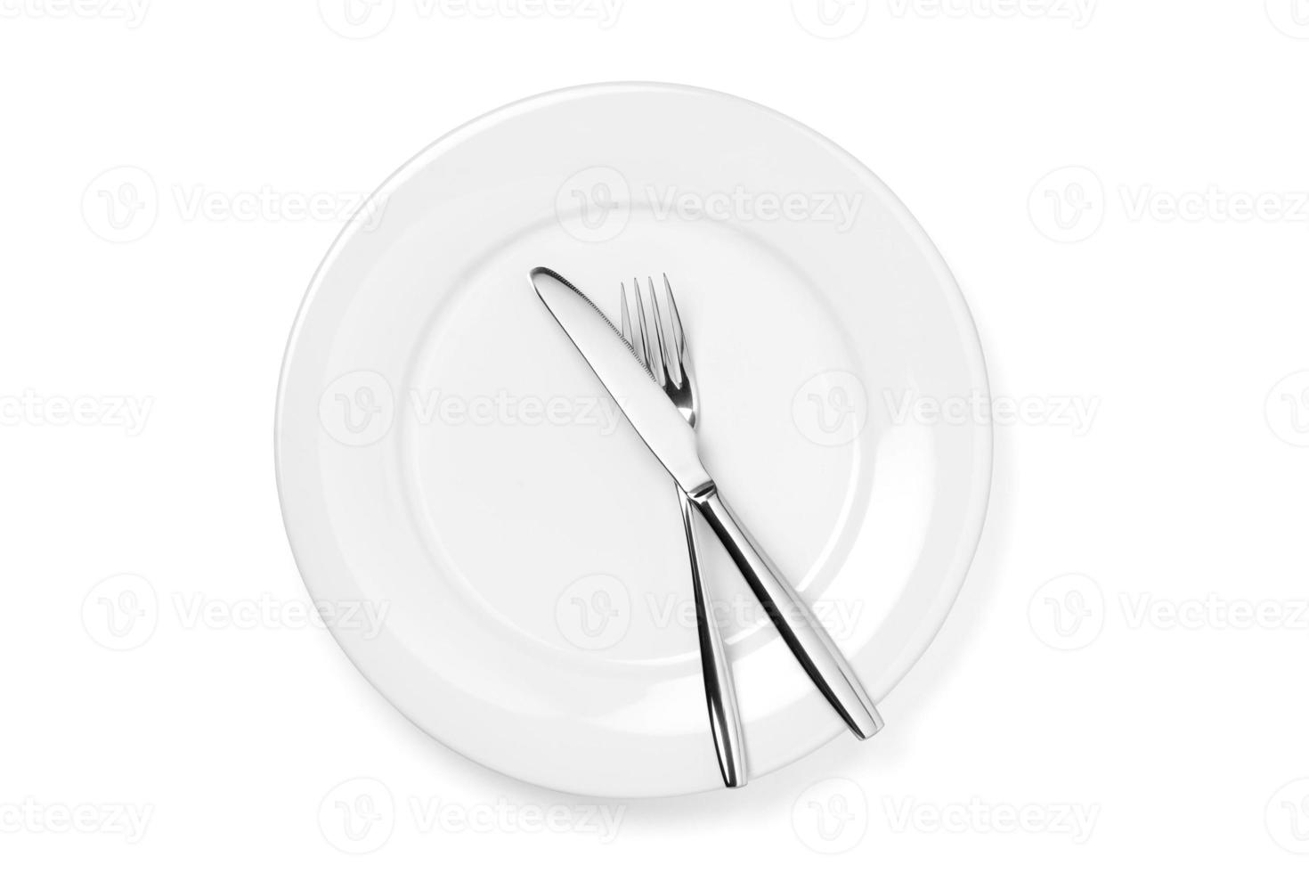 Empty plate with knife and fork isolated on a white background. photo