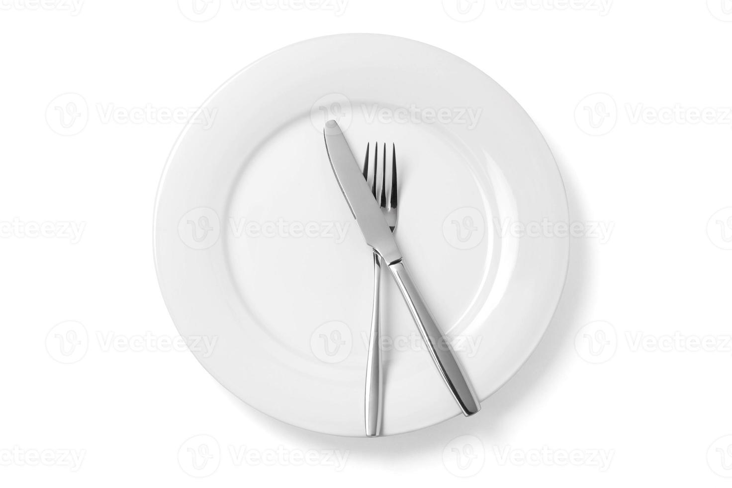 Empty plate with knife and fork isolated on a white background. photo