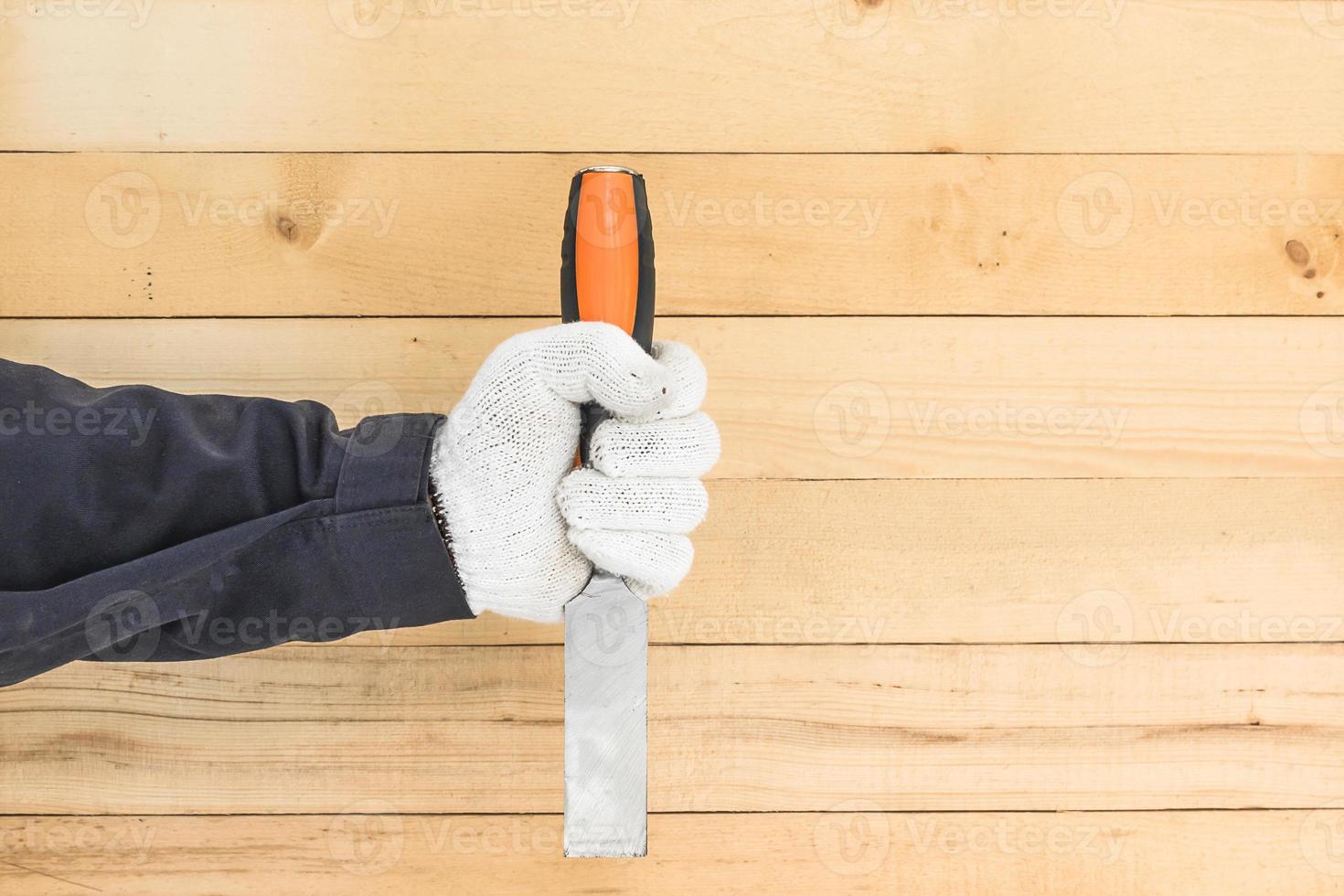 Hand in glove holding chisel photo