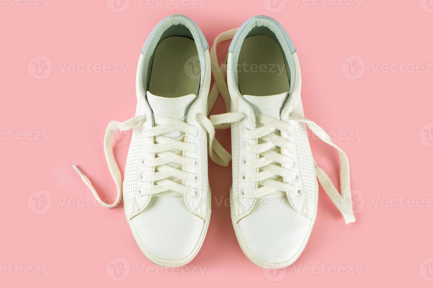 White sneakers on pink background photo