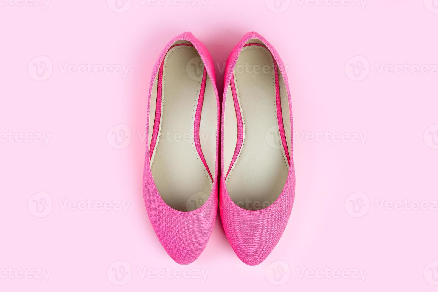 Pair of pink classic elegant shoes isolated on pink background with copy space photo