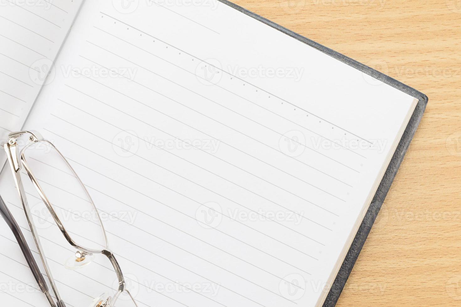 Notebook open blank page and Eyeglasses photo