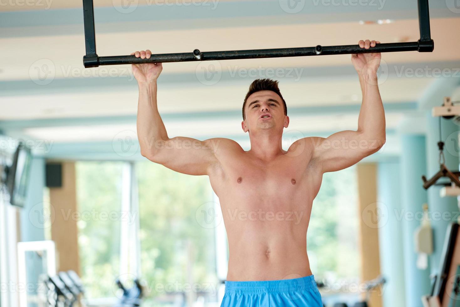 apuesto joven trabajando en el gimnasio foto