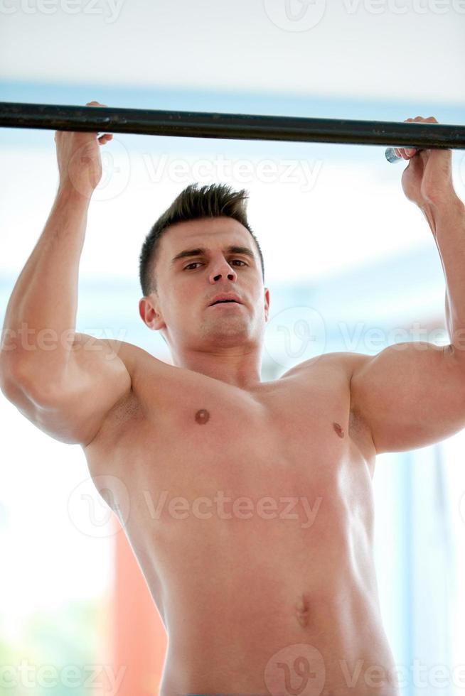 handsome young mand working out in gym photo
