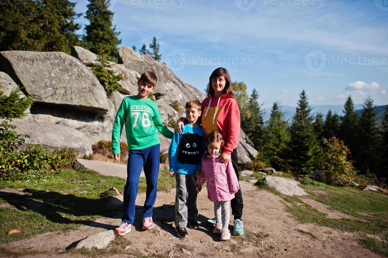 Mother with four kids resting in mountains. Family travel and hiking with childrens. photo