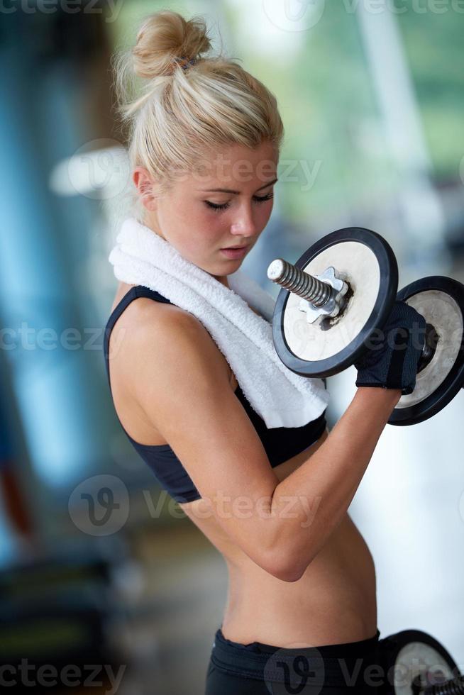 lifting some weights and working on her biceps in a gym photo