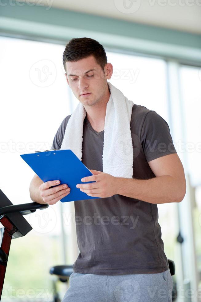 entrenador con portapapeles de pie en un gimnasio brillante foto