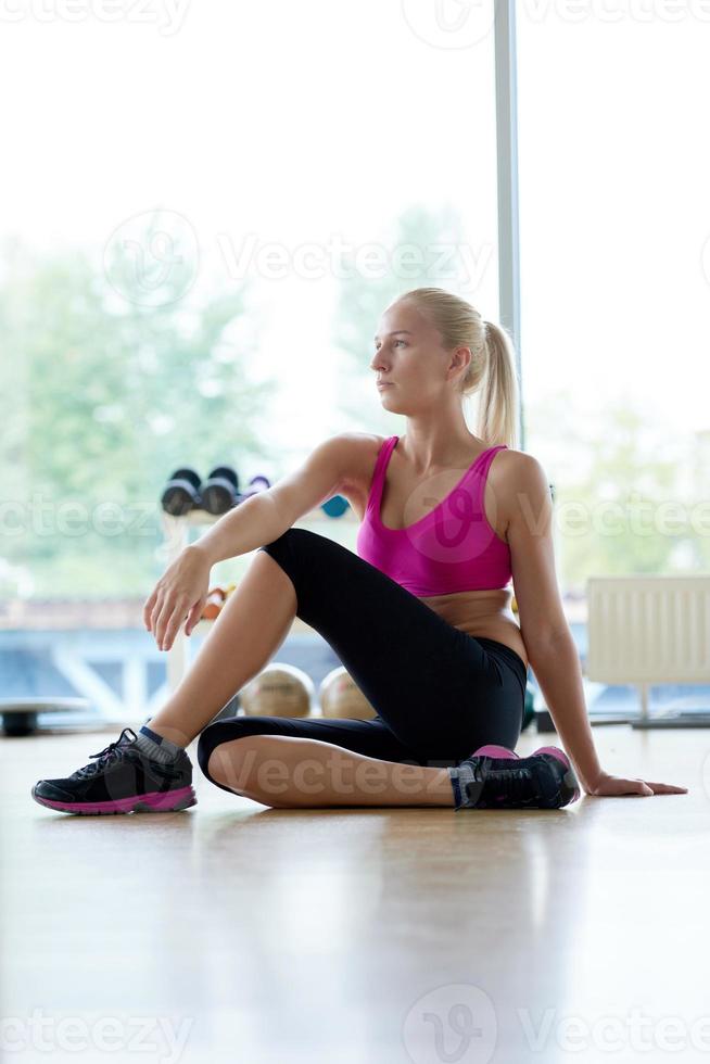 woman stretching and warming up for her training at a gym photo