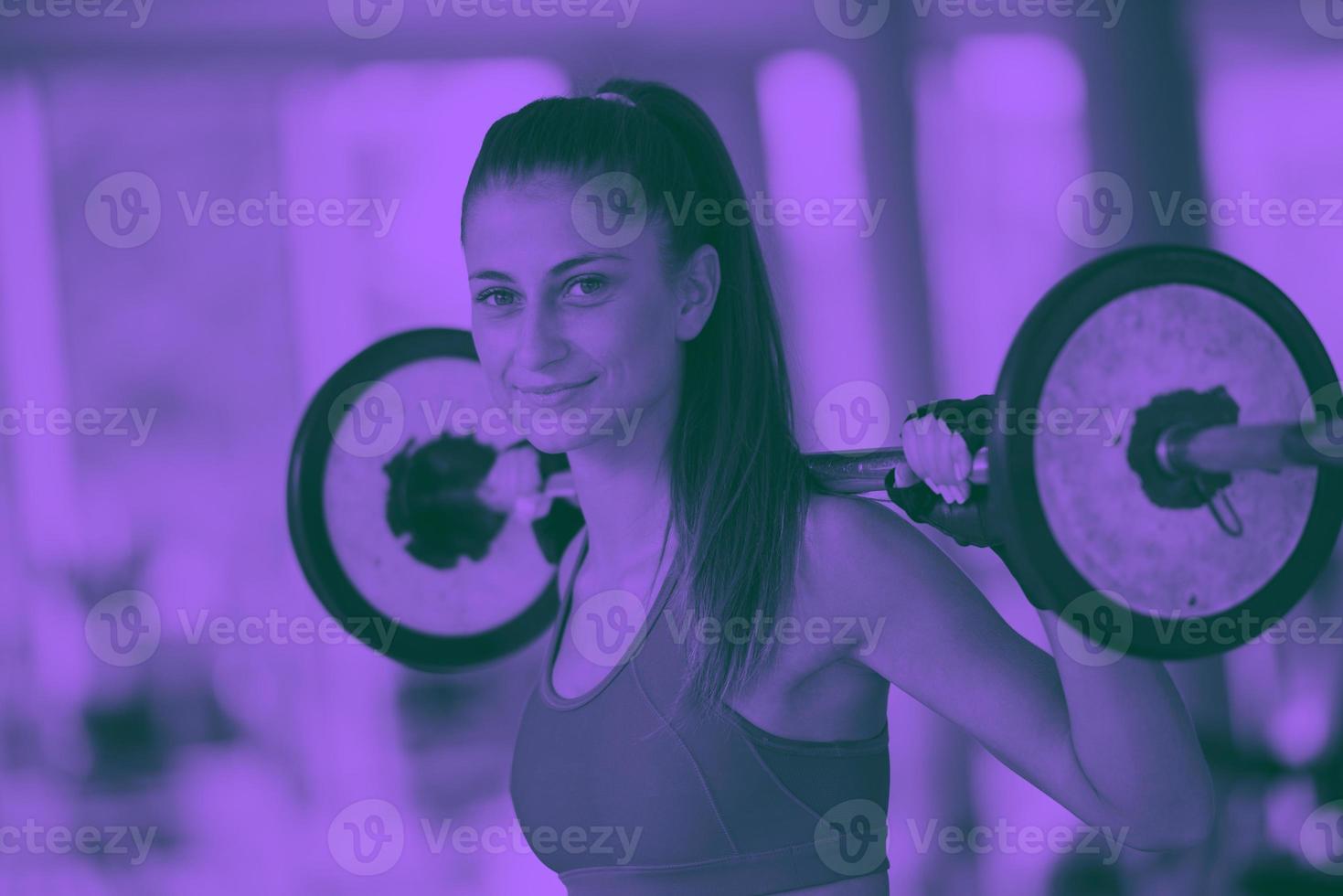 young woman in fitness gym lifting  weights photo