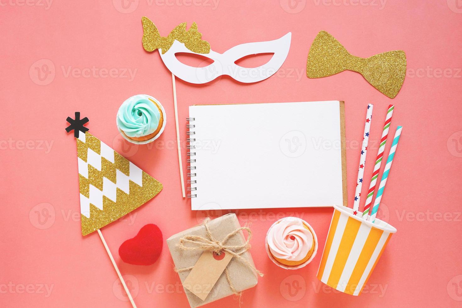 Cute party props, cake, blank notebook and gift box on colorful background, happy new year party celebration photo