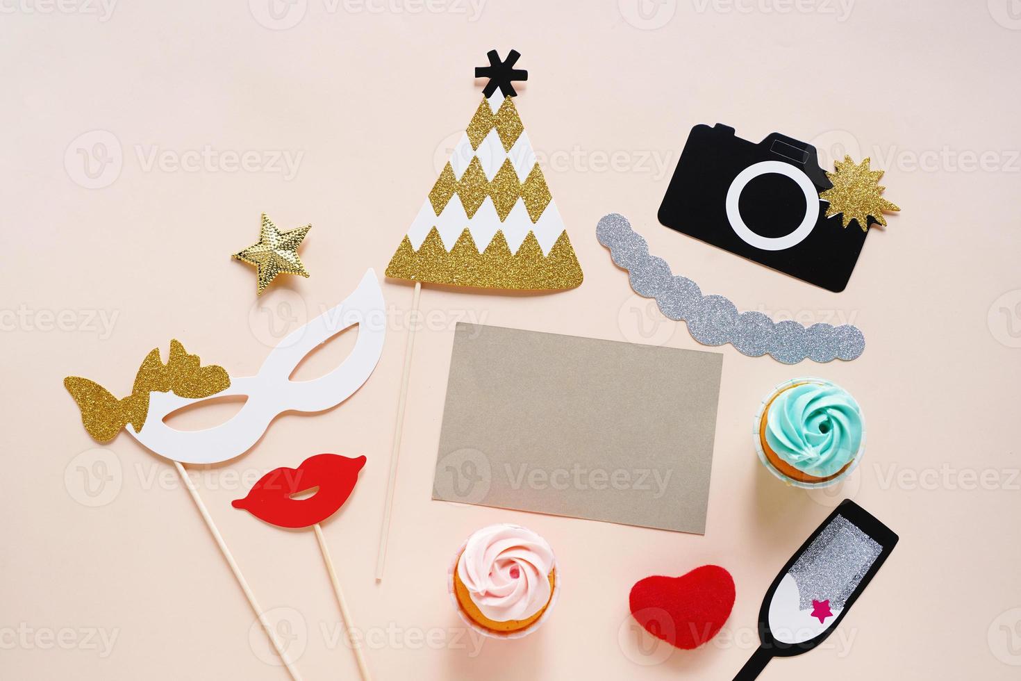 Flat lay of cute party props and cake with blank card on yellow background. Birthday, wedding party celebration photo